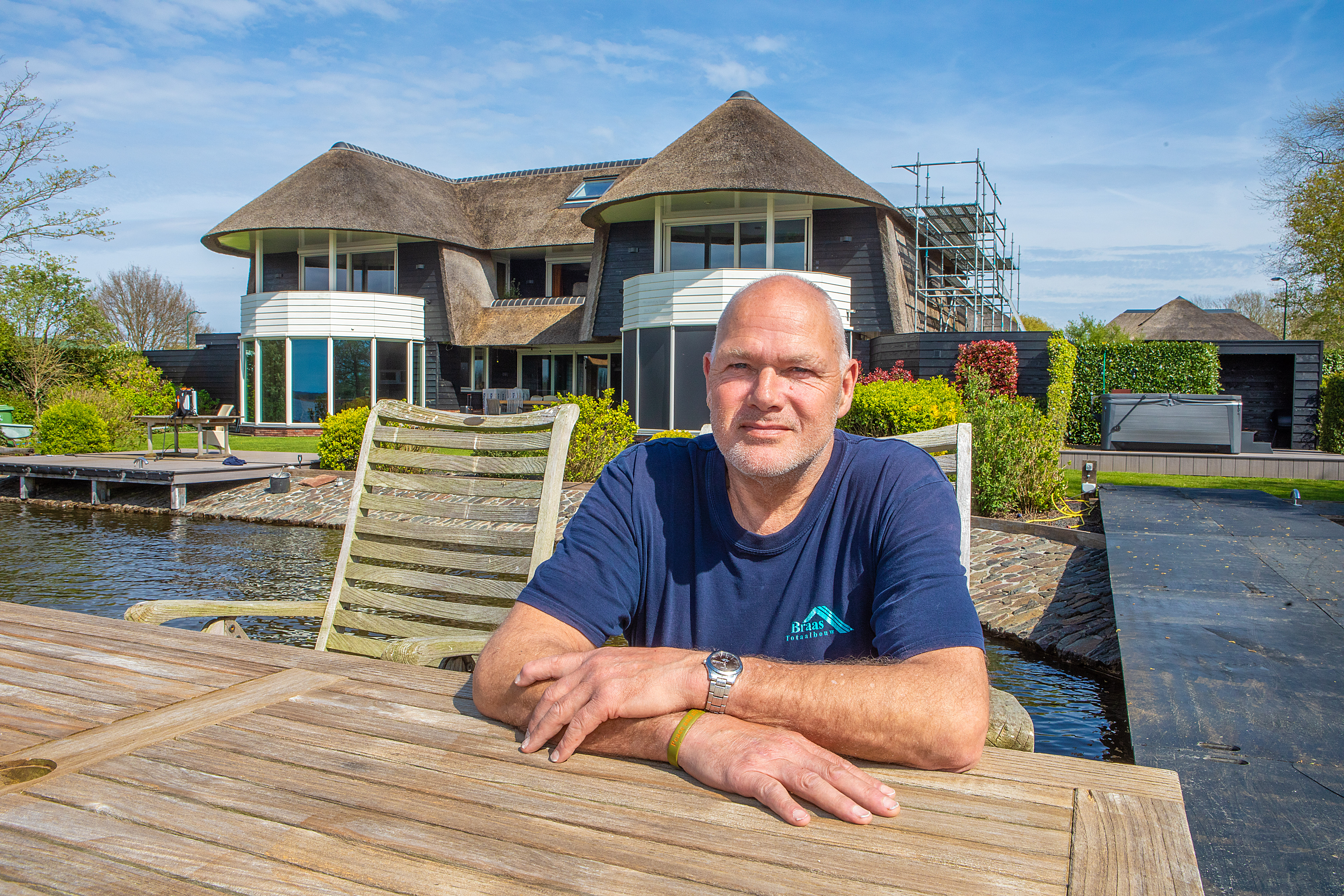 Een foto van John Braas, bewoner van Breukeleveen in de zon voor zijn woning.